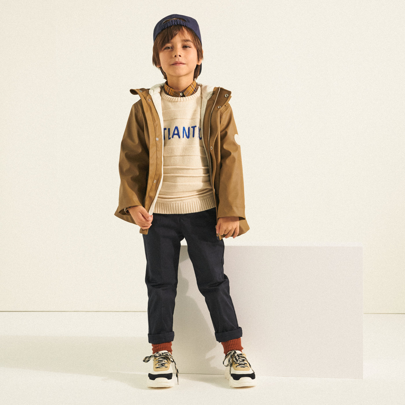 Boy in sweater and brown outerwear jacket from Bonpoint Spring Summer 2022 Collection
