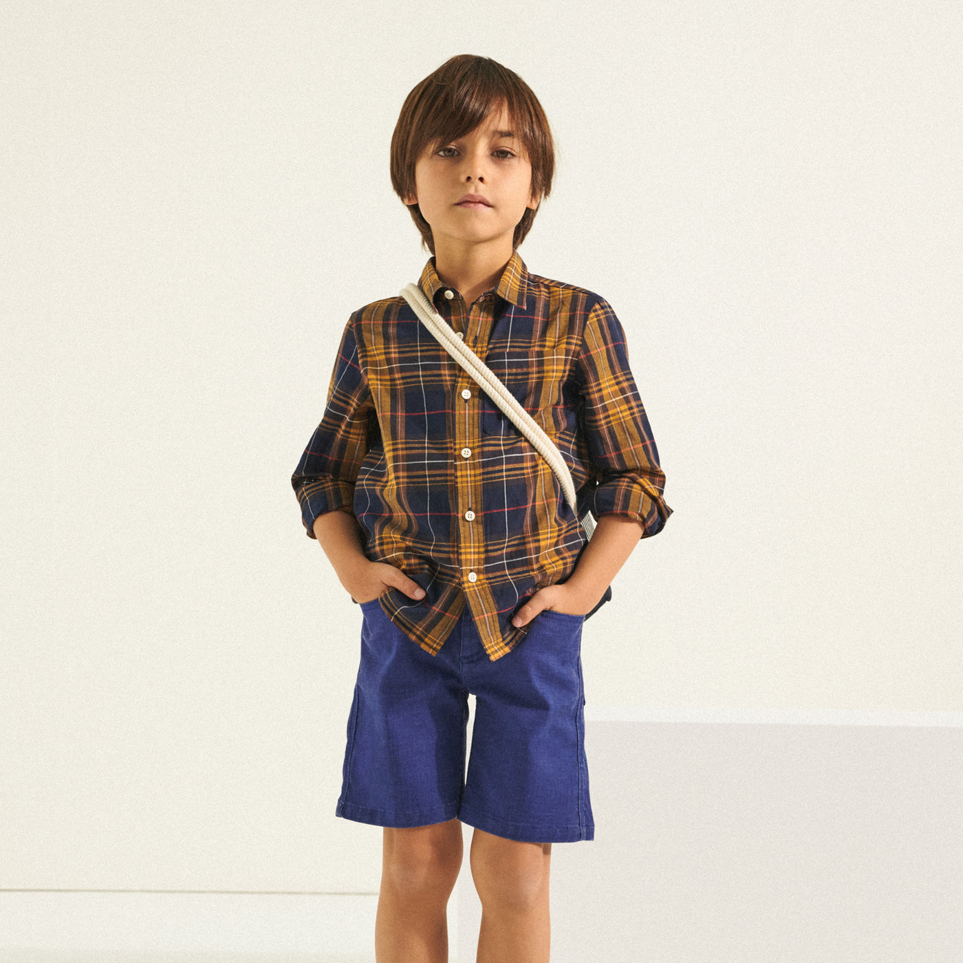 Boy in checkered shirt with blue shorts from Bonpoint Spring Summer 2022 Collection