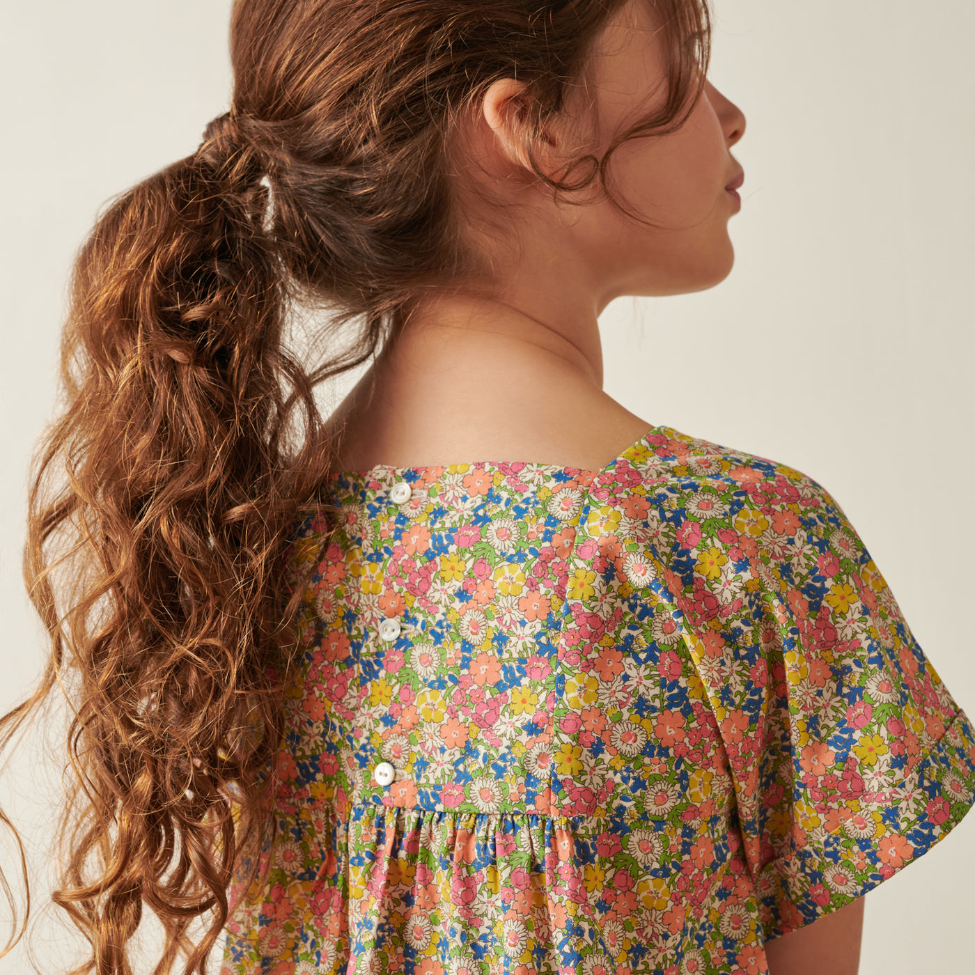 Back of girl in bright floral dress from Bonpoint Pre-Fall 2022 Collection
