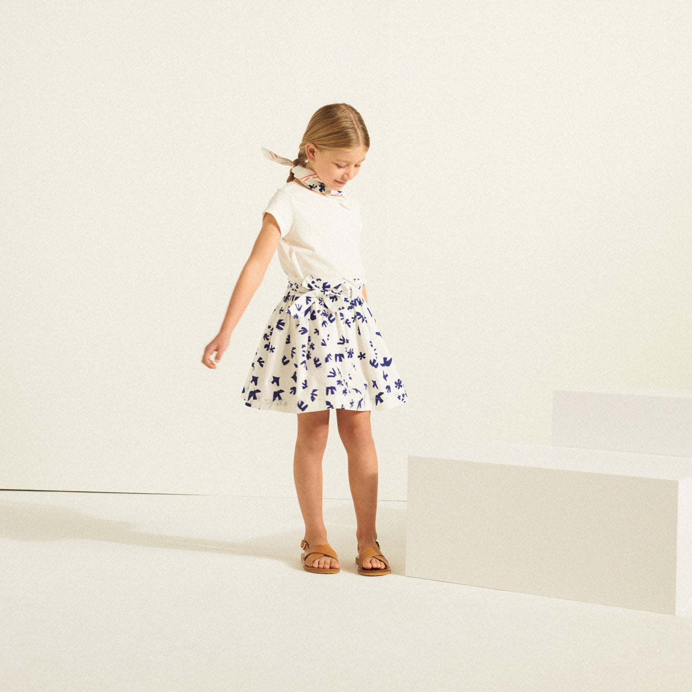 Girl in white shirt and blue detailed skirt from Bonpoint Spring Summer 2022 Collection