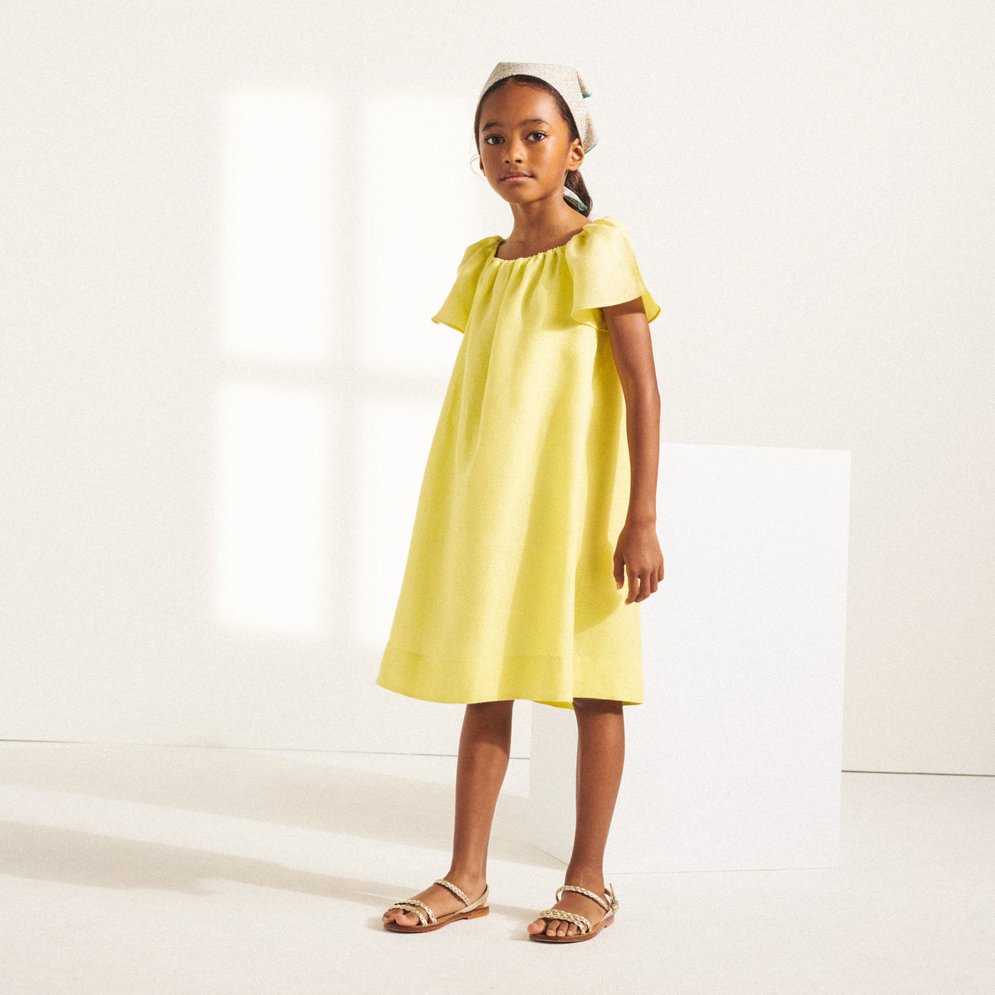 Girl standing in yellow dress from Bonpoint Spring Summer 2022 Collection