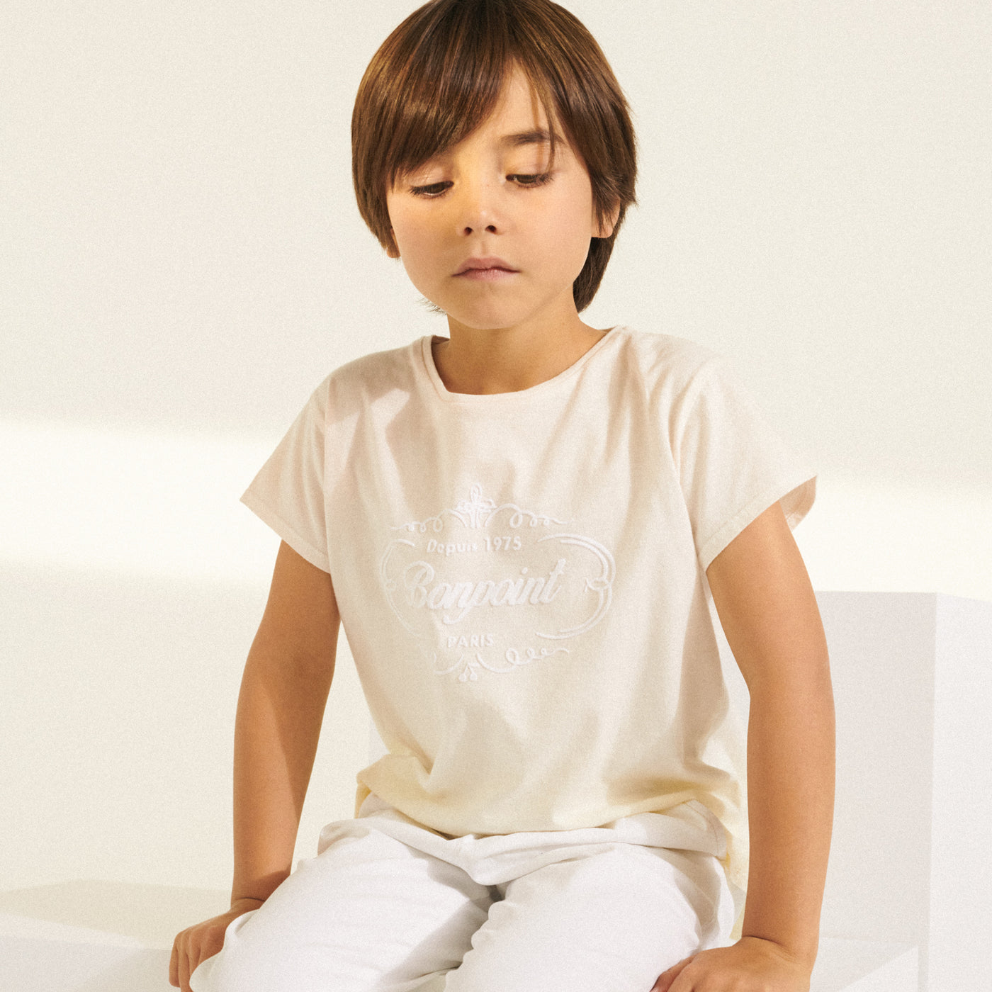 Boy in cream Bonpoint short sleeve shirt from Bonpoint Spring Summer 2022 Collection
