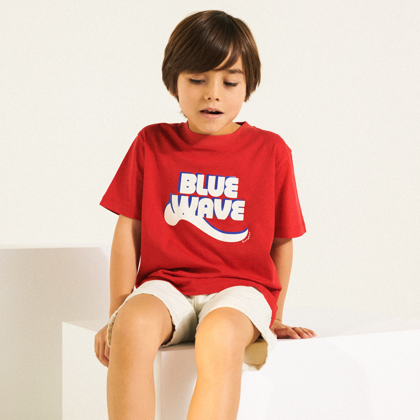Boy in graphic red shirt from Bonpoint Spring Summer 2022 Collection